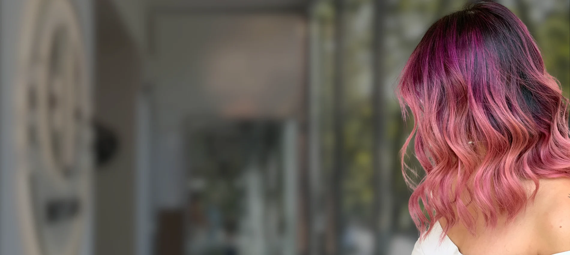 Wavy shoulder-length bob with a vivid magenta-to-pink colour melt at Ela Beauty Salon